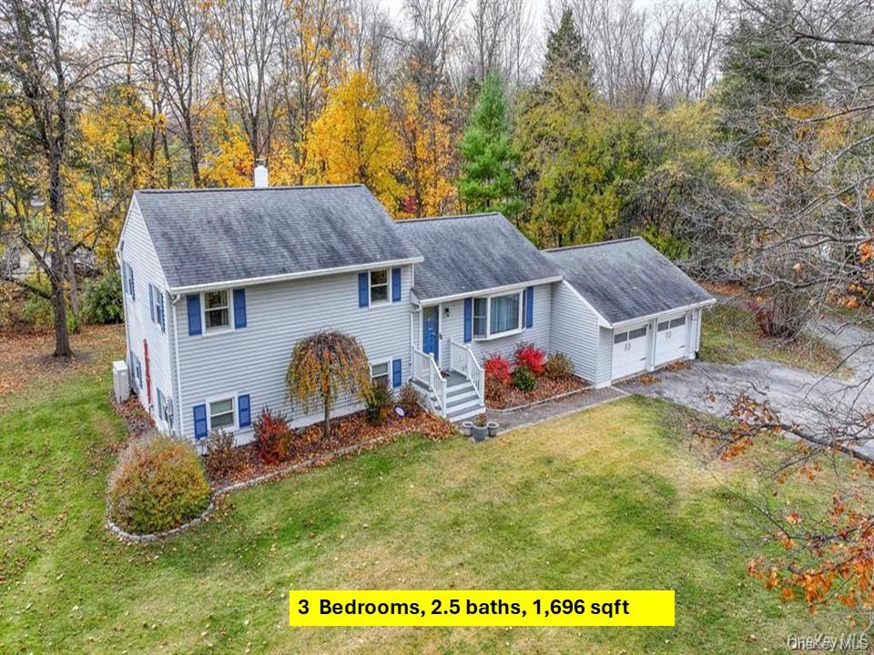 a view of a big house with table and chairs under an umbrella