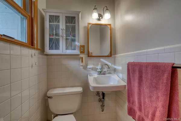 a bathroom with a toilet sink and mirror