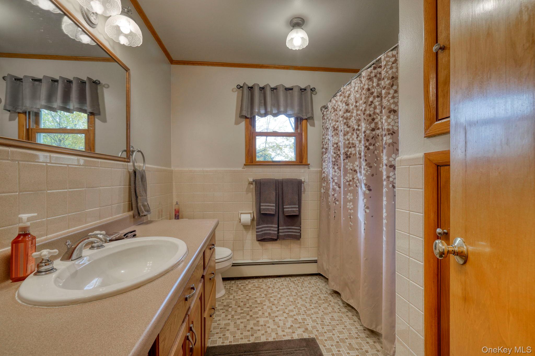 4 Irene Court Fishkill, NY 12524 - Photo 18 of 46 Second floor hall bathroom with vanity, tile walls, wainscoting, ornamental molding,