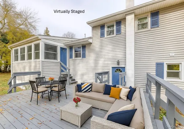 a view of a patio with couches table and chairs and wooden floor