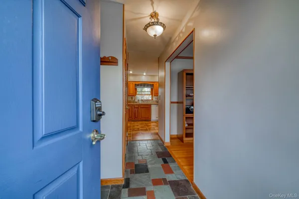a view of a hallway with wooden floor and windows