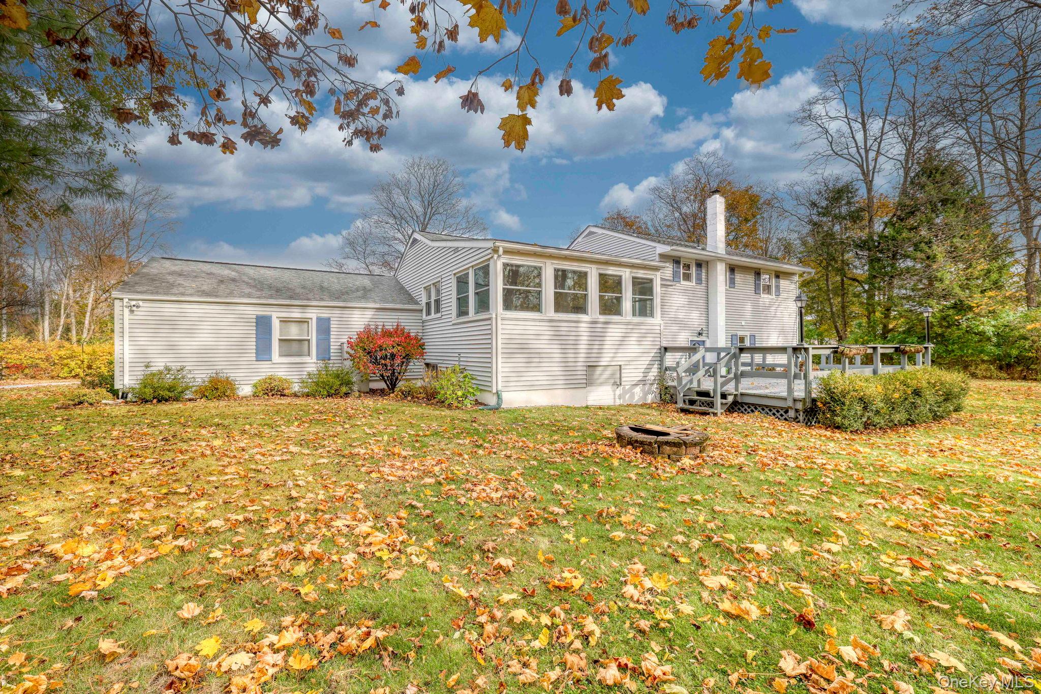 4 Irene Court Fishkill, NY 12524 - Photo 46 of 47 Back of property with a chimney, a yard, a deck, a sunroom, and an outdoor fire pit
