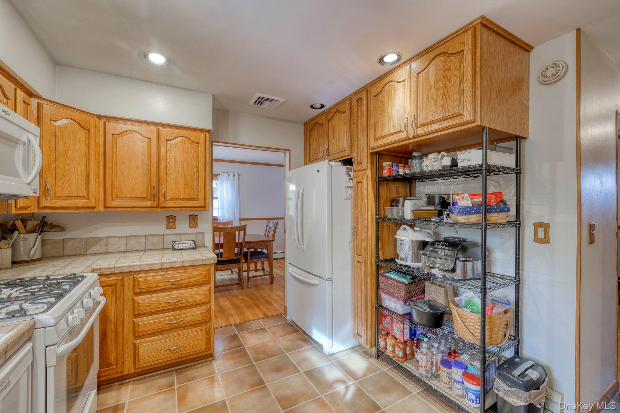 4 Irene Court Fishkill, NY 12524 - Photo 7 of 46 Kitchen with white appliances, light tile patterned floors, tile counters, and recessed lighting