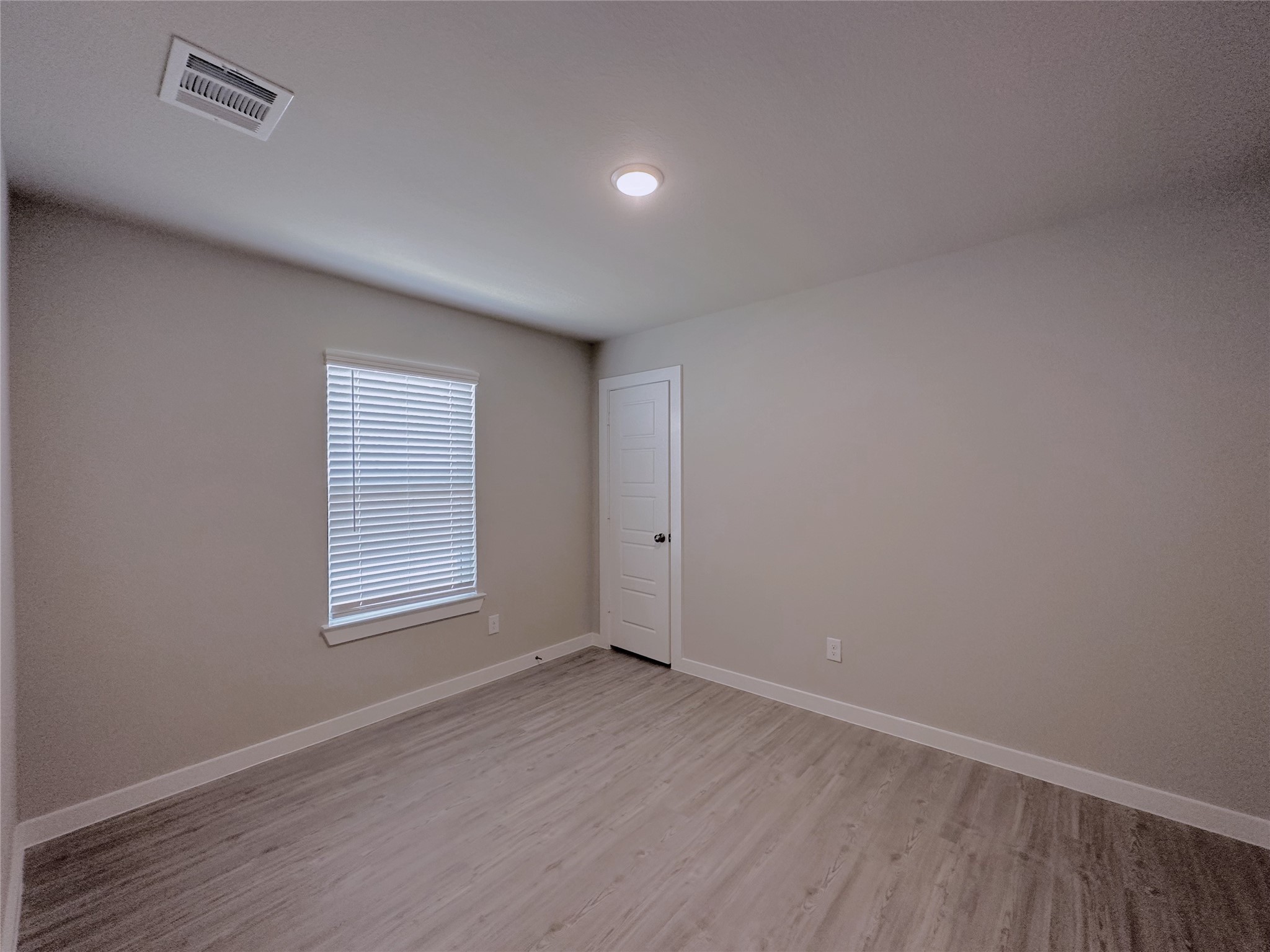 5835 Sunrise Btm Lane Fulshear, TX 77441 - Photo 13 of 22 an empty room with wooden floor and windows