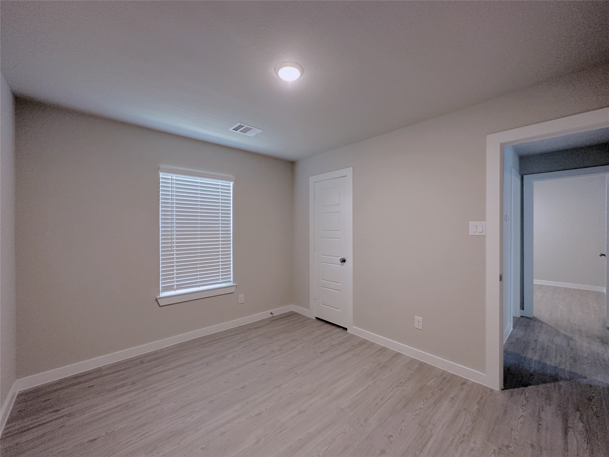 5835 Sunrise Btm Lane Fulshear, TX 77441 - Photo 14 of 22 an empty room with wooden floor and windows
