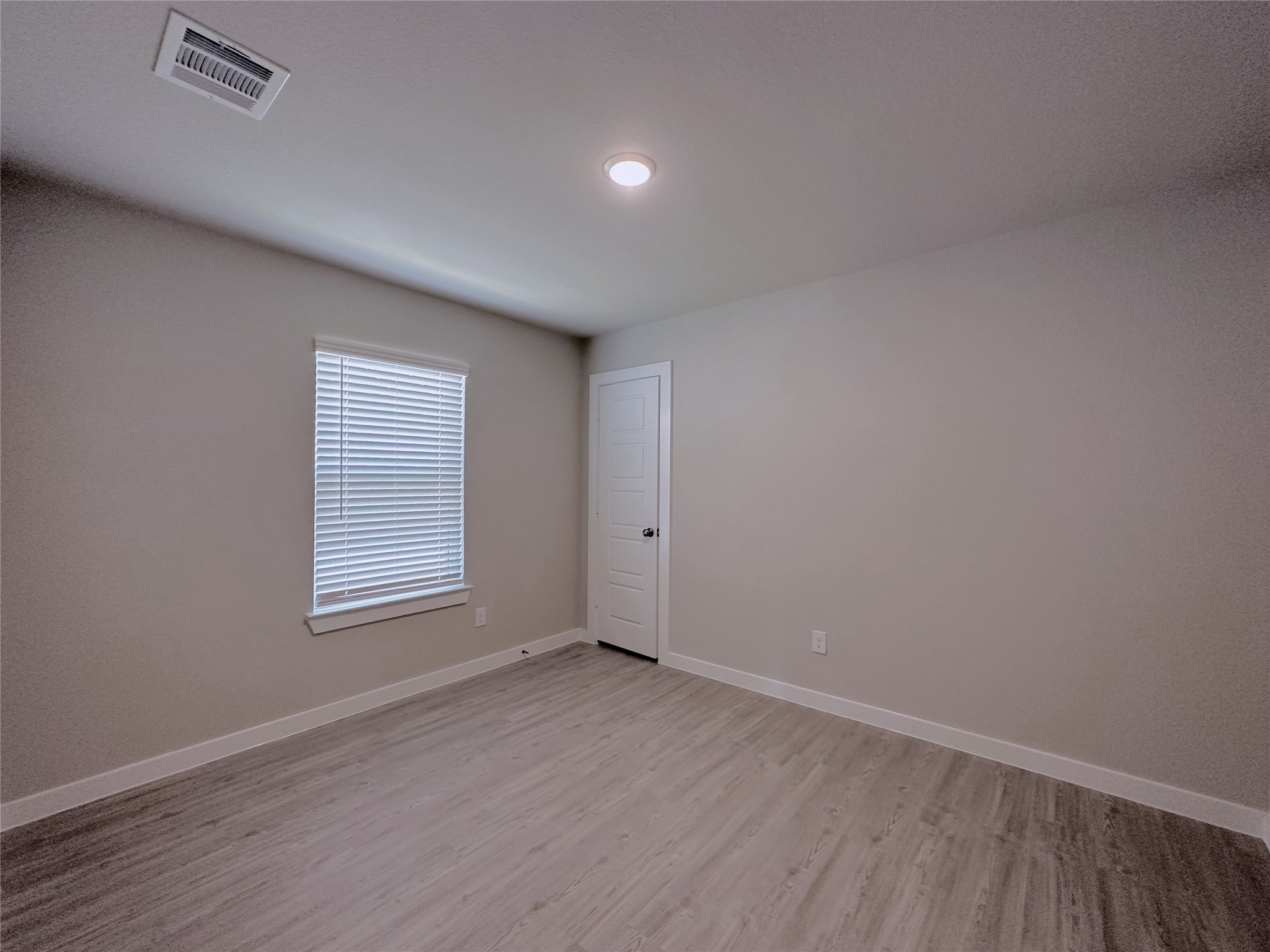 5835 Sunrise Btm Lane Fulshear, TX 77441 - Photo 15 of 22 an empty room with wooden floor and windows