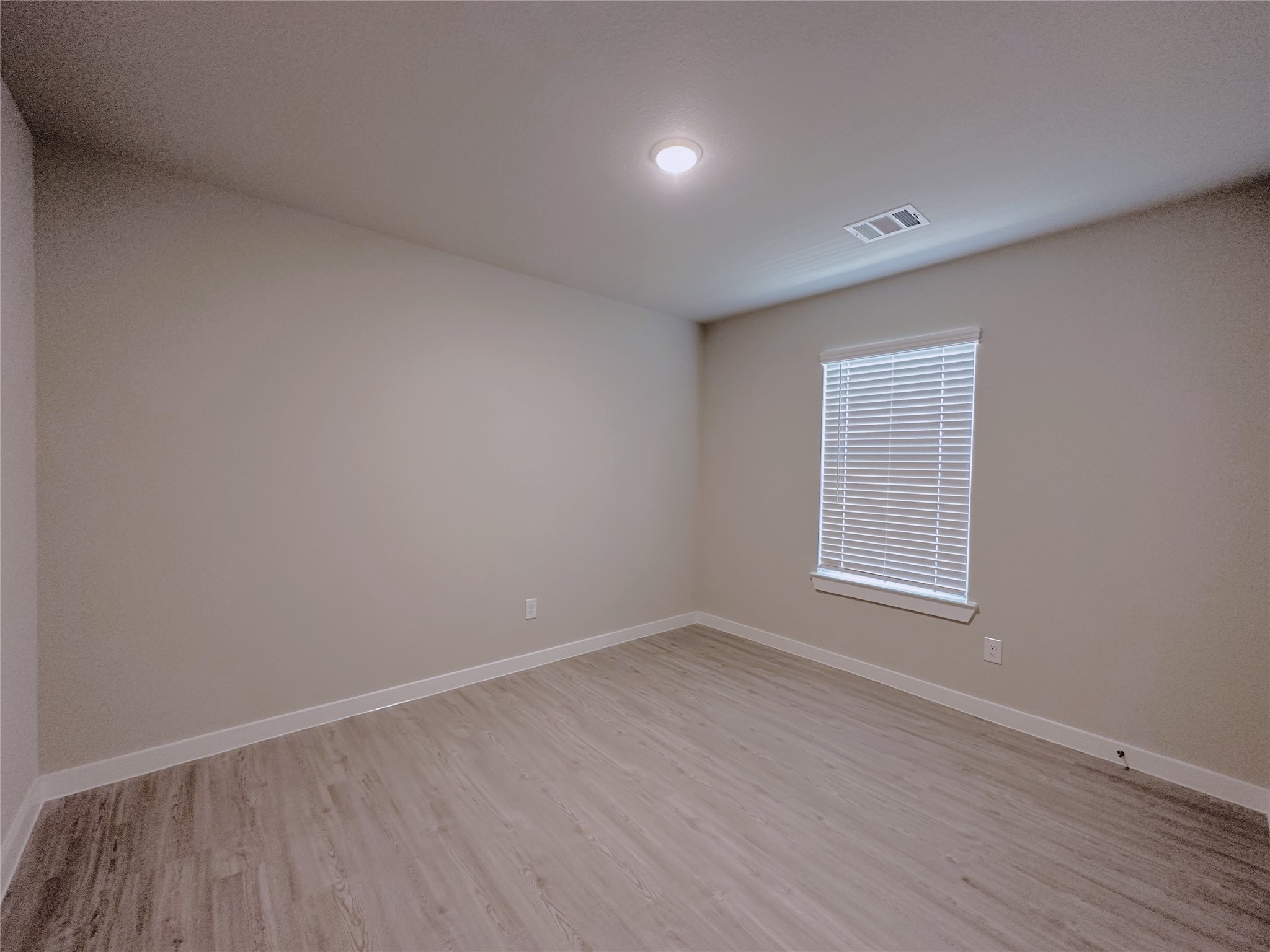 5835 Sunrise Btm Lane Fulshear, TX 77441 - Photo 17 of 22 an empty room with wooden floor and windows