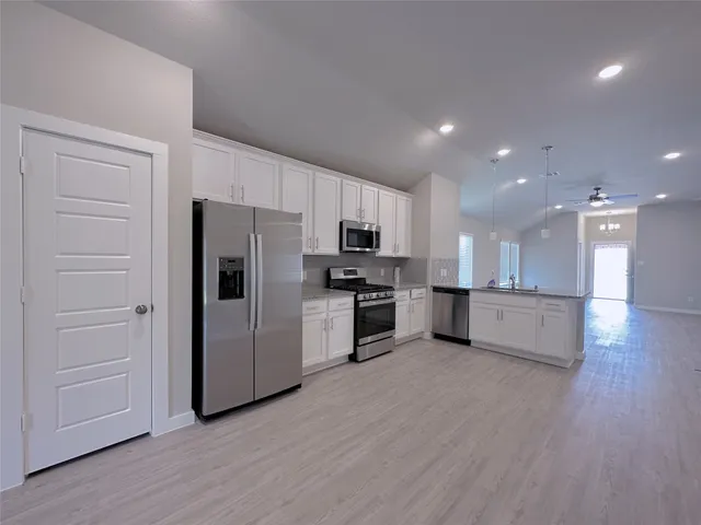 a kitchen with a refrigerator and a stove top oven