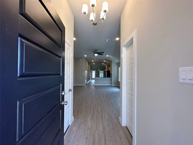 a view of a hallway with wooden floor and staircase