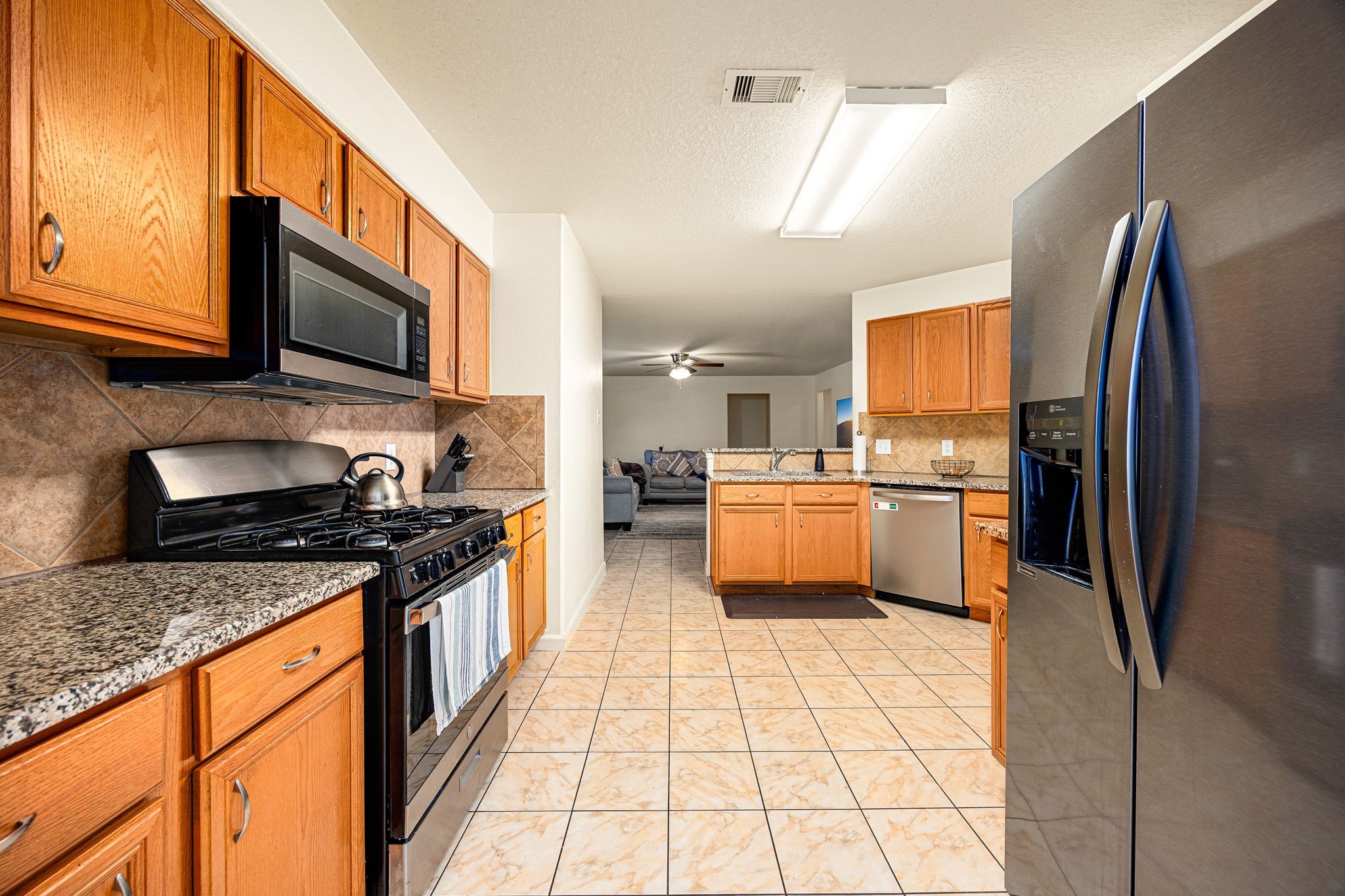 16945 Scenic Knoll Conroe, TX 77385 - Photo 14 of 39 a large kitchen with stainless steel appliances granite countertop a stove a sink dishwasher and a refrigerator