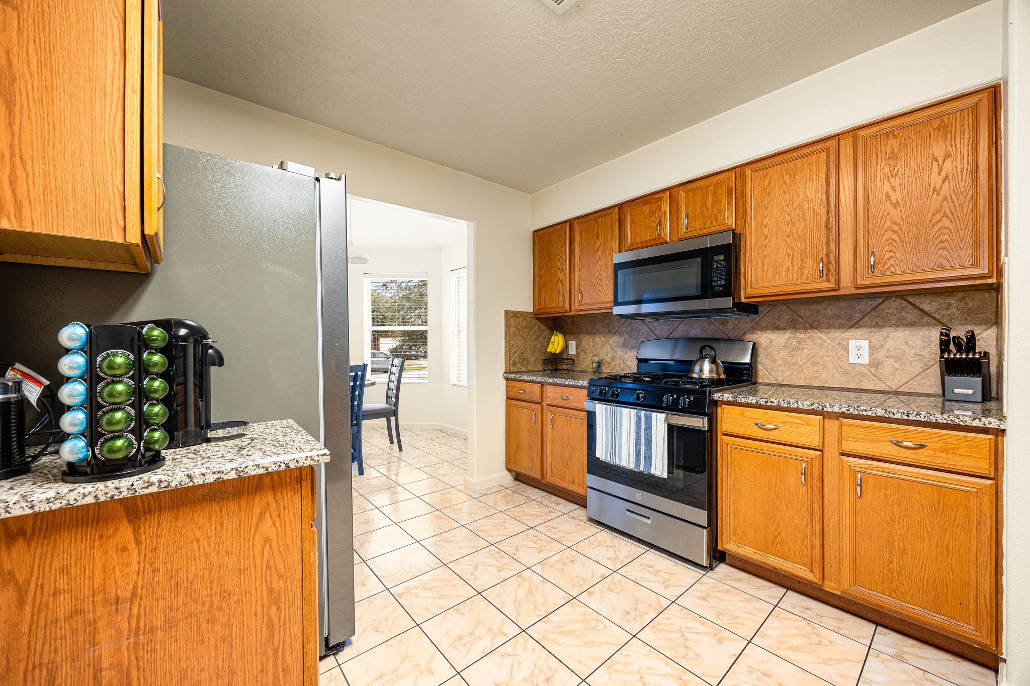 16945 Scenic Knoll Conroe, TX 77385 - Photo 16 of 39 a kitchen with stainless steel appliances granite countertop a stove a sink and a microwave