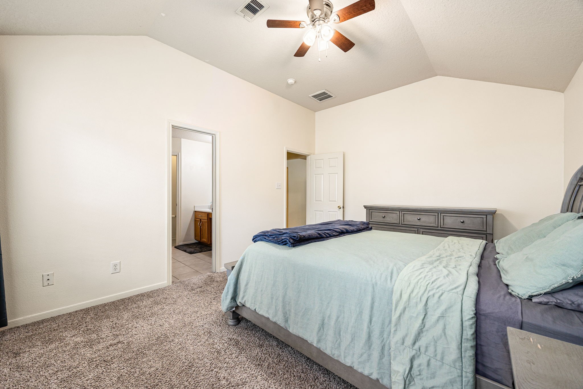 16945 Scenic Knoll Conroe, TX 77385 - Photo 23 of 39 a bedroom with a bed and a chandelier