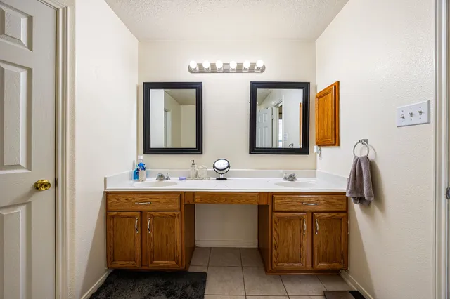 a bathroom with a double vanity sink and mirror