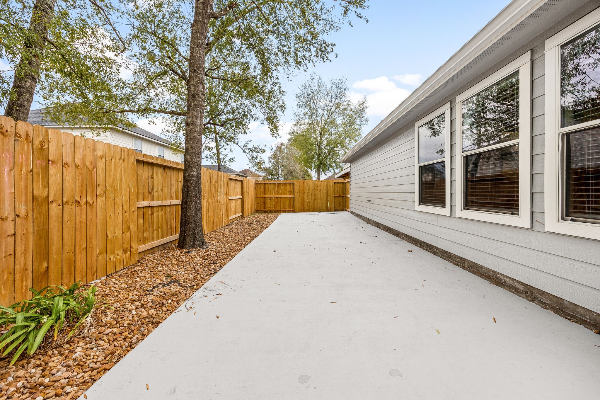 16945 Scenic Knoll Conroe, TX 77385 - Photo 34 of 39 a view of a backyard with large trees and wooden fence