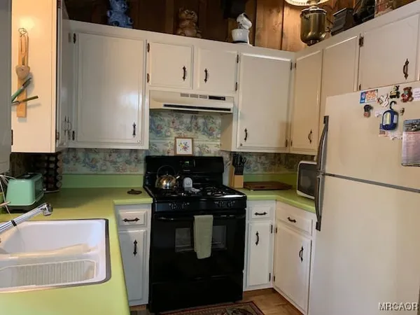 a kitchen with a sink a stove and refrigerator