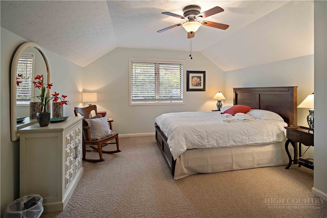 265 Leatherwood Road Banner Elk, NC 28604 - Photo 25 of 42 a bedroom with bed and a chandelier