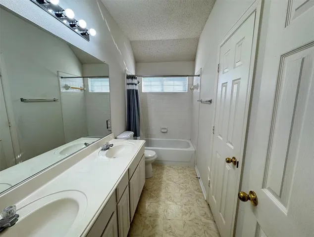 a bathroom with a sink a toilet a mirror and shower