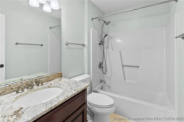 a bathroom with a granite countertop sink toilet mirror and shower