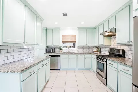 a kitchen with a sink stove top oven and cabinets