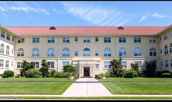 a front view of multi story residential apartment building with yard