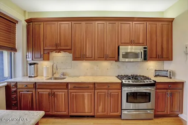 a kitchen with stainless steel appliances granite countertop a stove a microwave and wooden cabinets