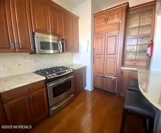 a kitchen with stainless steel appliances granite countertop a stove a sink and a microwave