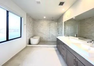 a bathroom with a granite countertop sink mirror and a bathtub
