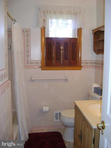 9823 Forge Park Road Perry Hall, MD 21128 - Photo 14 of 14 a bathroom with a toilet a sink and mirror