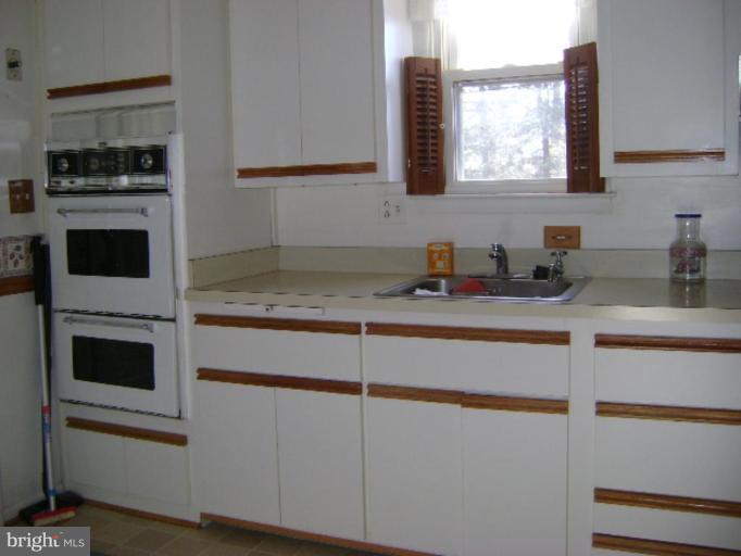 9823 Forge Park Road Perry Hall, MD 21128 - Photo 7 of 14 a kitchen with granite countertop white cabinets and white appliances