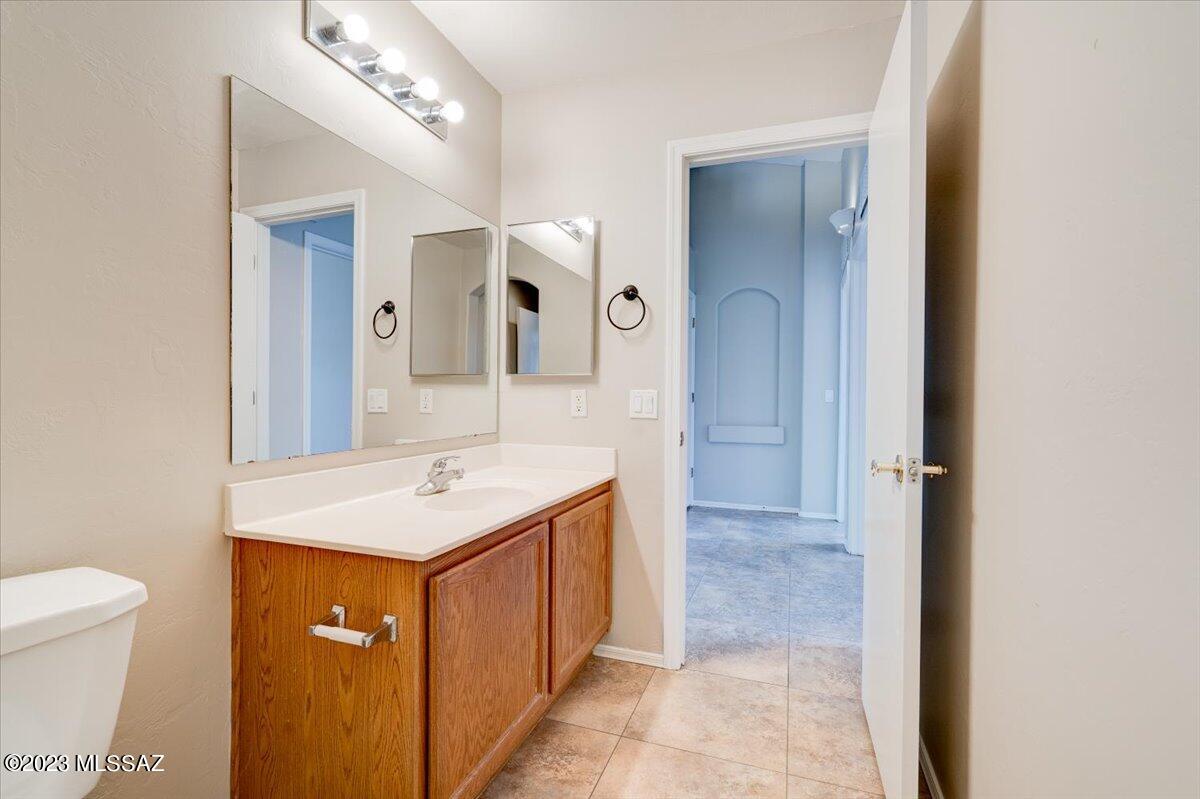 4686 South Valley Road Tucson, AZ 85714 - Photo 27 of 37 a bathroom with a sink a toilet and mirror