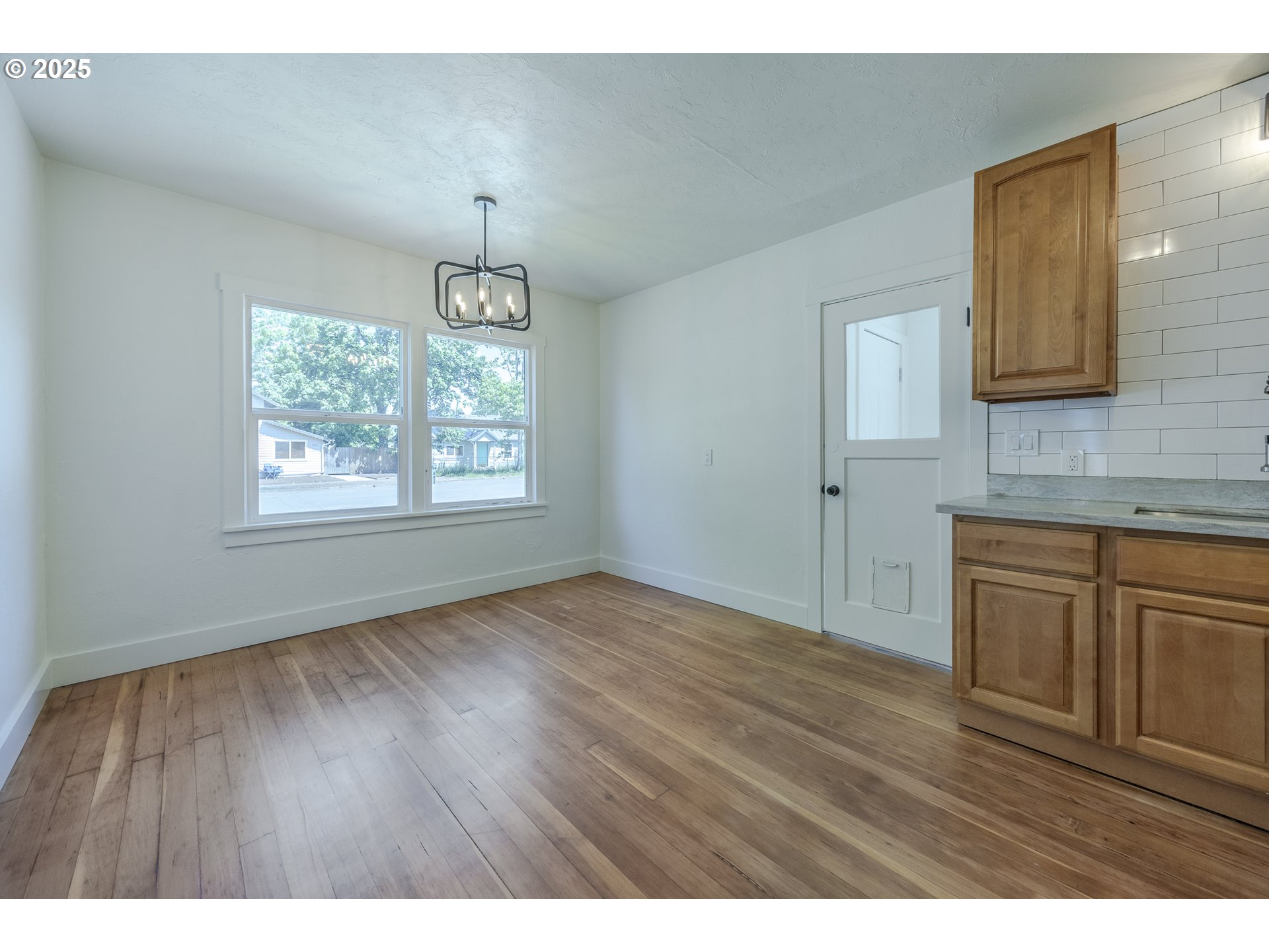 155 B Street Springfield, OR 97477 - Photo 14 of 42 a view of an empty room with window and wooden floor
