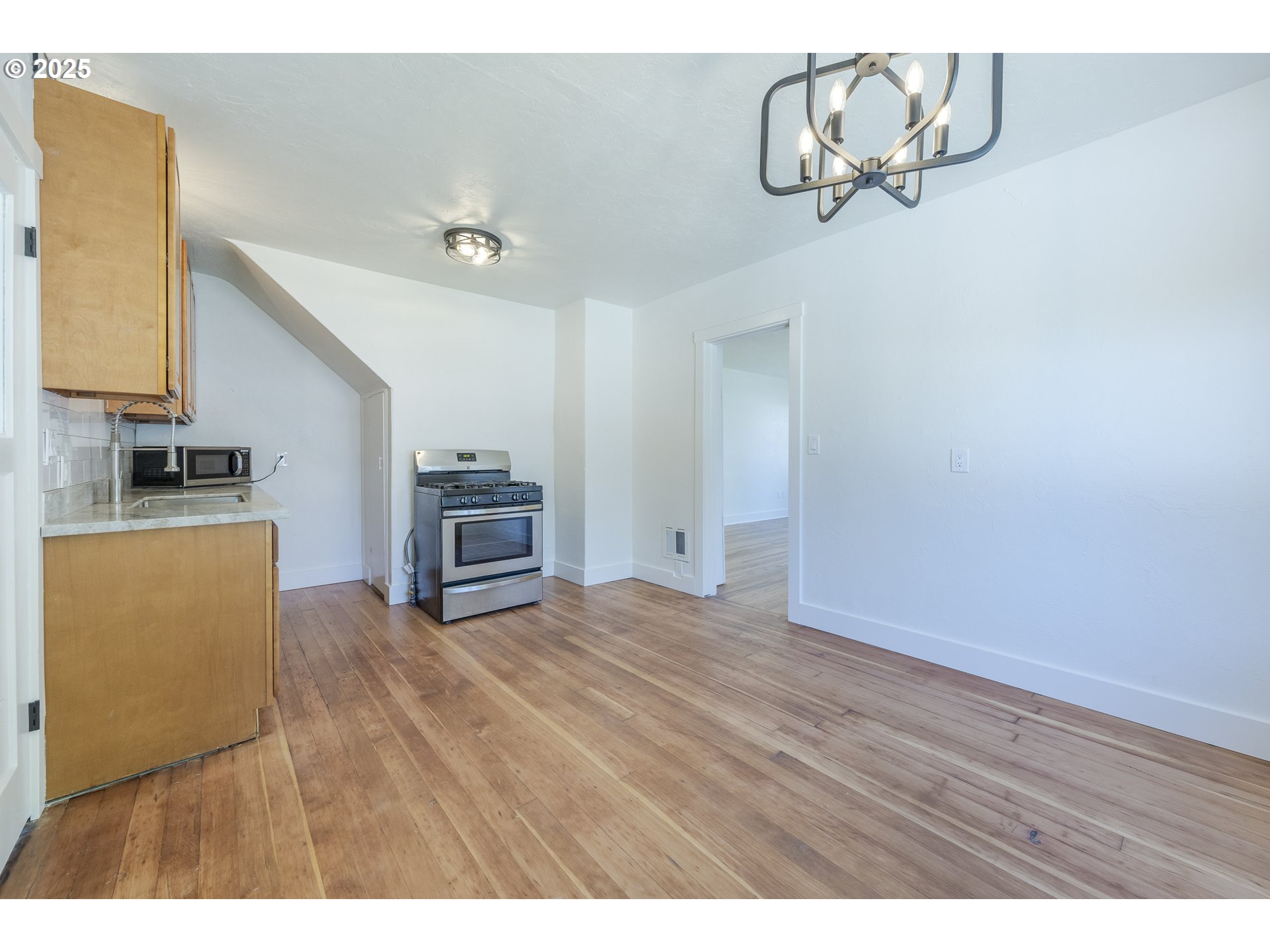 155 B Street Springfield, OR 97477 - Photo 18 of 42 a view of kitchen and empty room with wooden floor