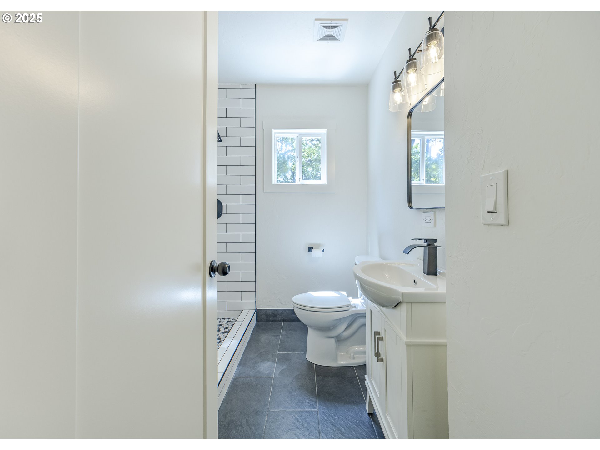 155 B Street Springfield, OR 97477 - Photo 23 of 42 a bathroom with a toilet sink a shower and a mirror