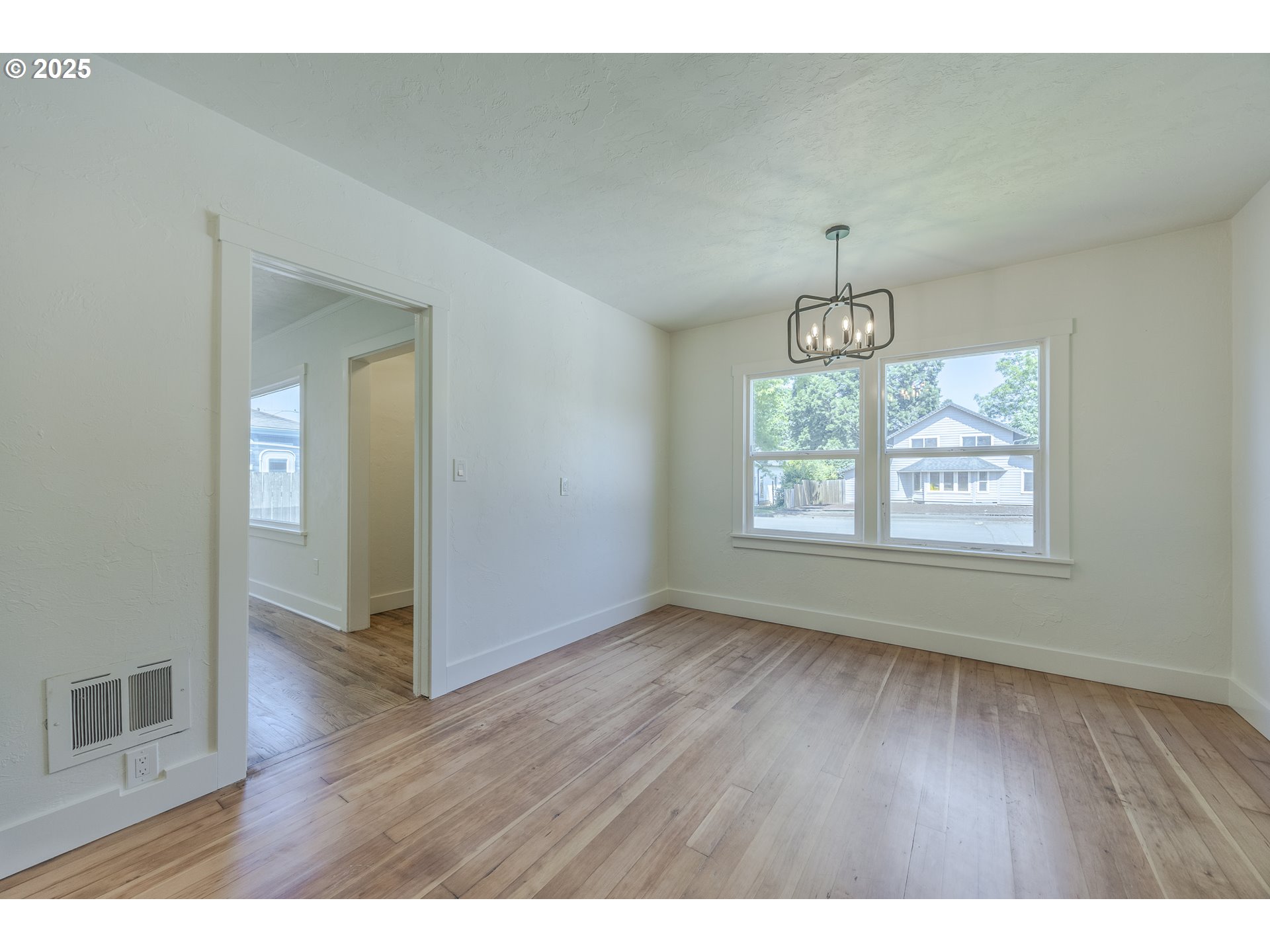155 B Street Springfield, OR 97477 - Photo 9 of 42 a view of an empty room with window and hardwood floor