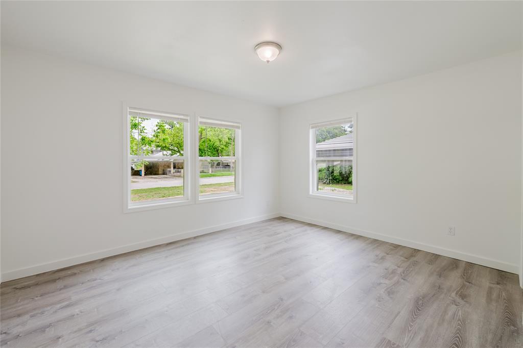 524 West Roberts Street Gorman, TX 76454 - Photo 16 of 35 an empty room with wooden floor and windows