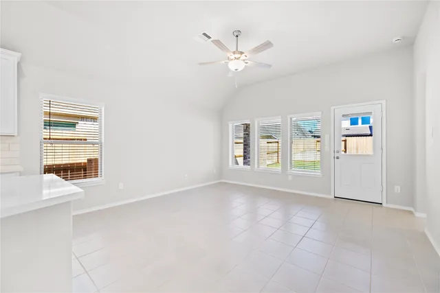 an empty room with windows and fan