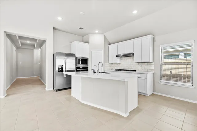 a kitchen with white cabinets and stainless steel appliances