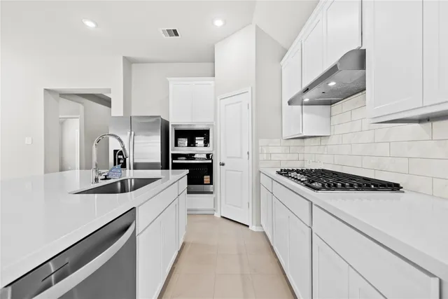 a kitchen with stainless steel appliances a sink stove and cabinets