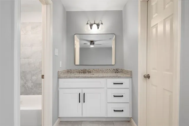 a bathroom with a tub sink and mirror