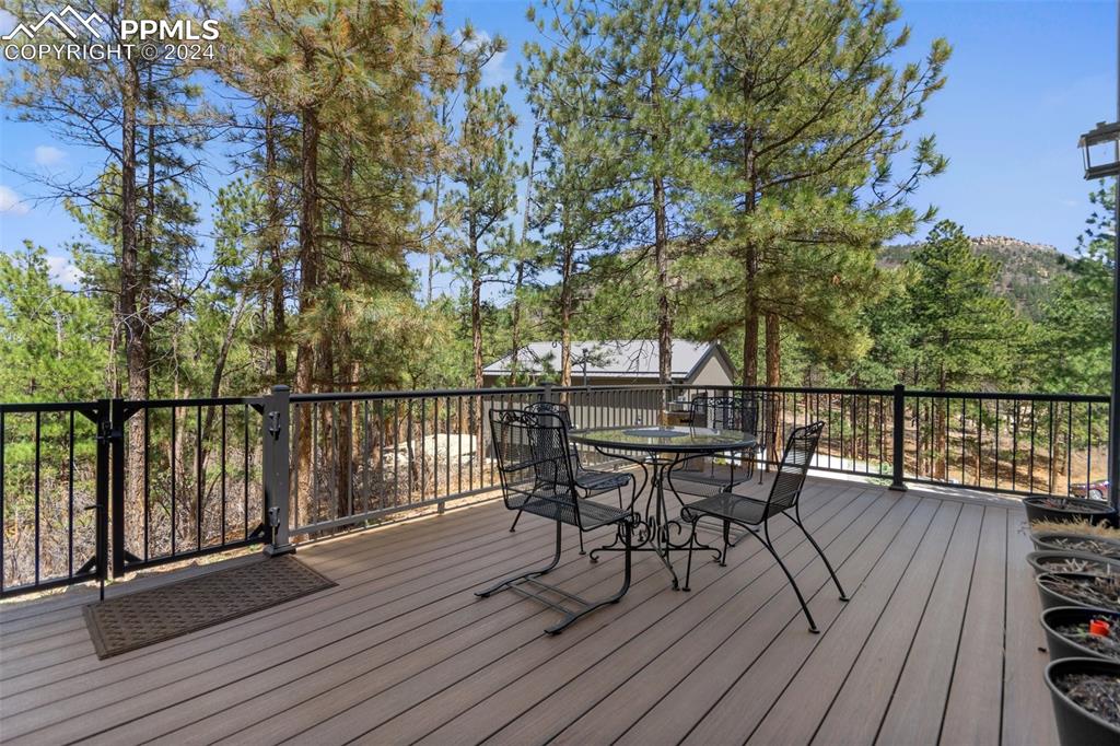 5090 South Perry Park Road Sedalia, CO 80135 - Photo 37 of 50 a view of a deck with table and chairs and wooden floor