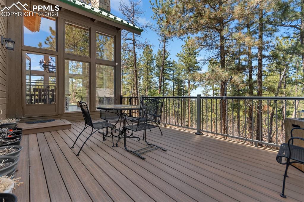 5090 South Perry Park Road Sedalia, CO 80135 - Photo 38 of 50 a view of a roof deck with table and chairs wooden floor and fence
