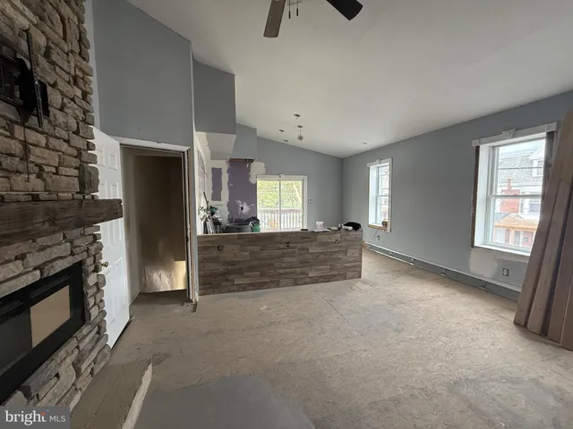 a view of an empty room with wooden floor and windows