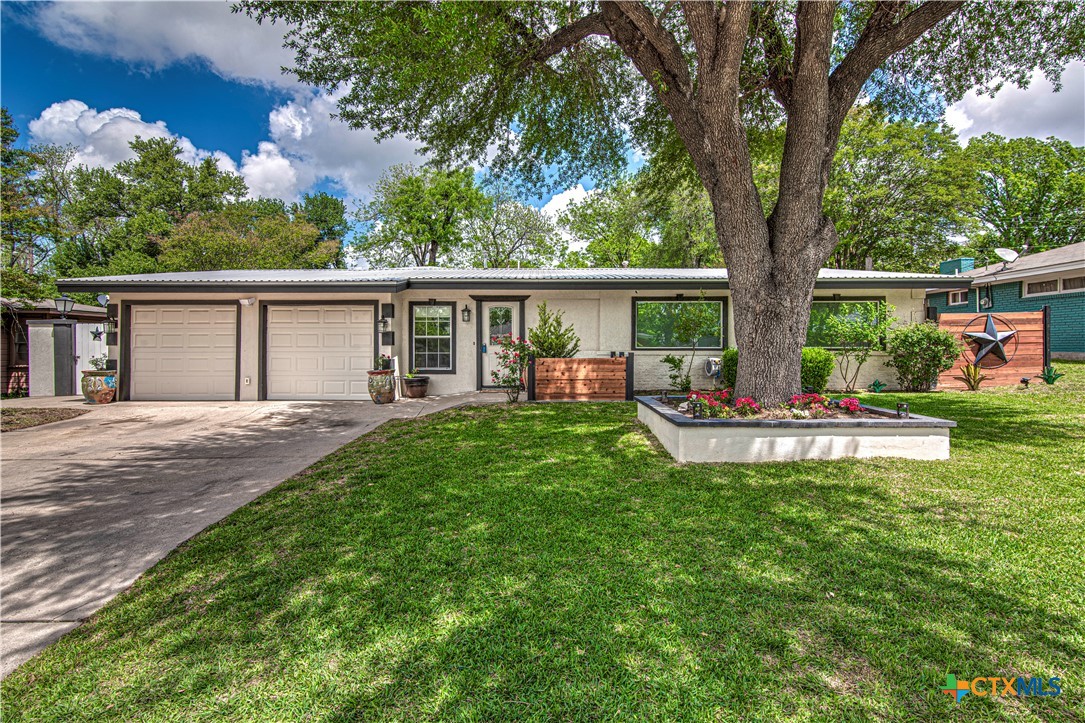 a view of a house with backyard and sitting area