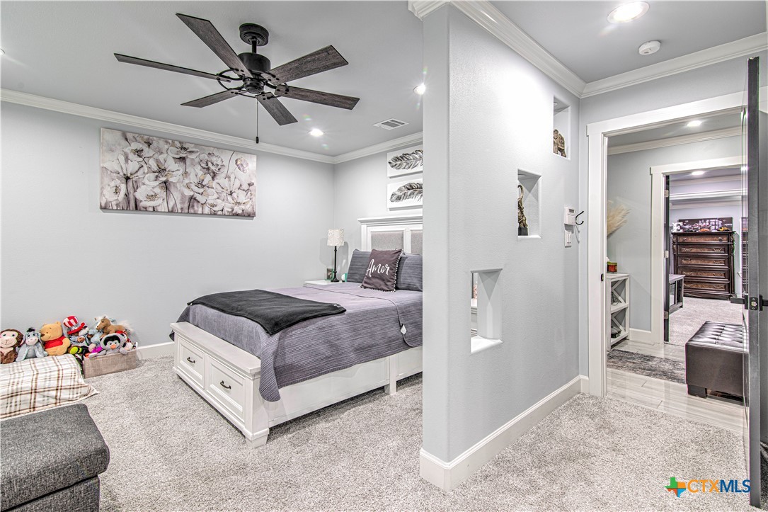 10 West Zenith Avenue Temple, TX 76501 - Photo 29 of 48 a bedroom with a bed and a chandelier