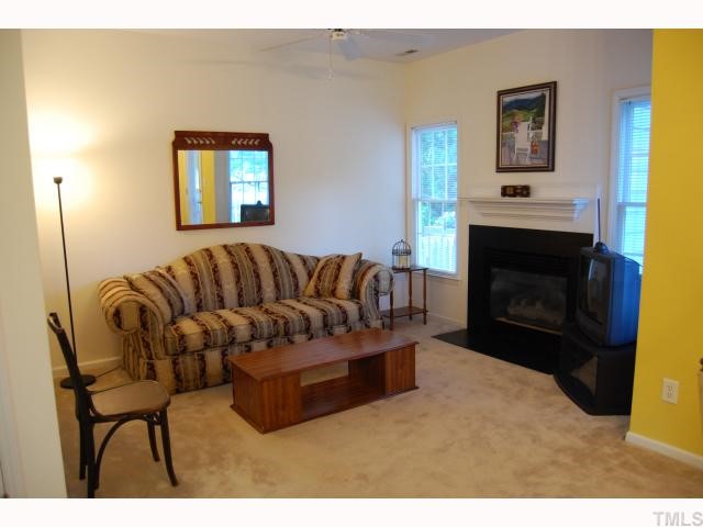 8320 Hempshire Place, Unit 101 Raleigh, NC 27613 - Photo 4 of 12 a living room with a couch and a fireplace