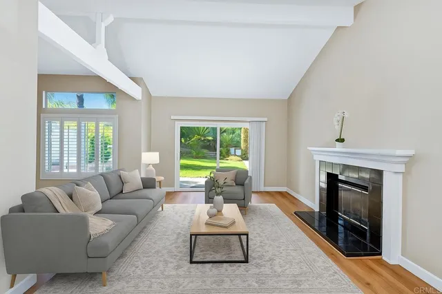 a living room with furniture a fireplace and a large window