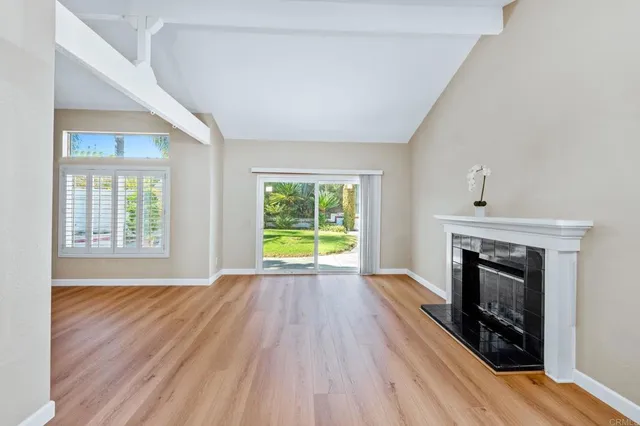 a view of empty room with wooden floor and fireplace