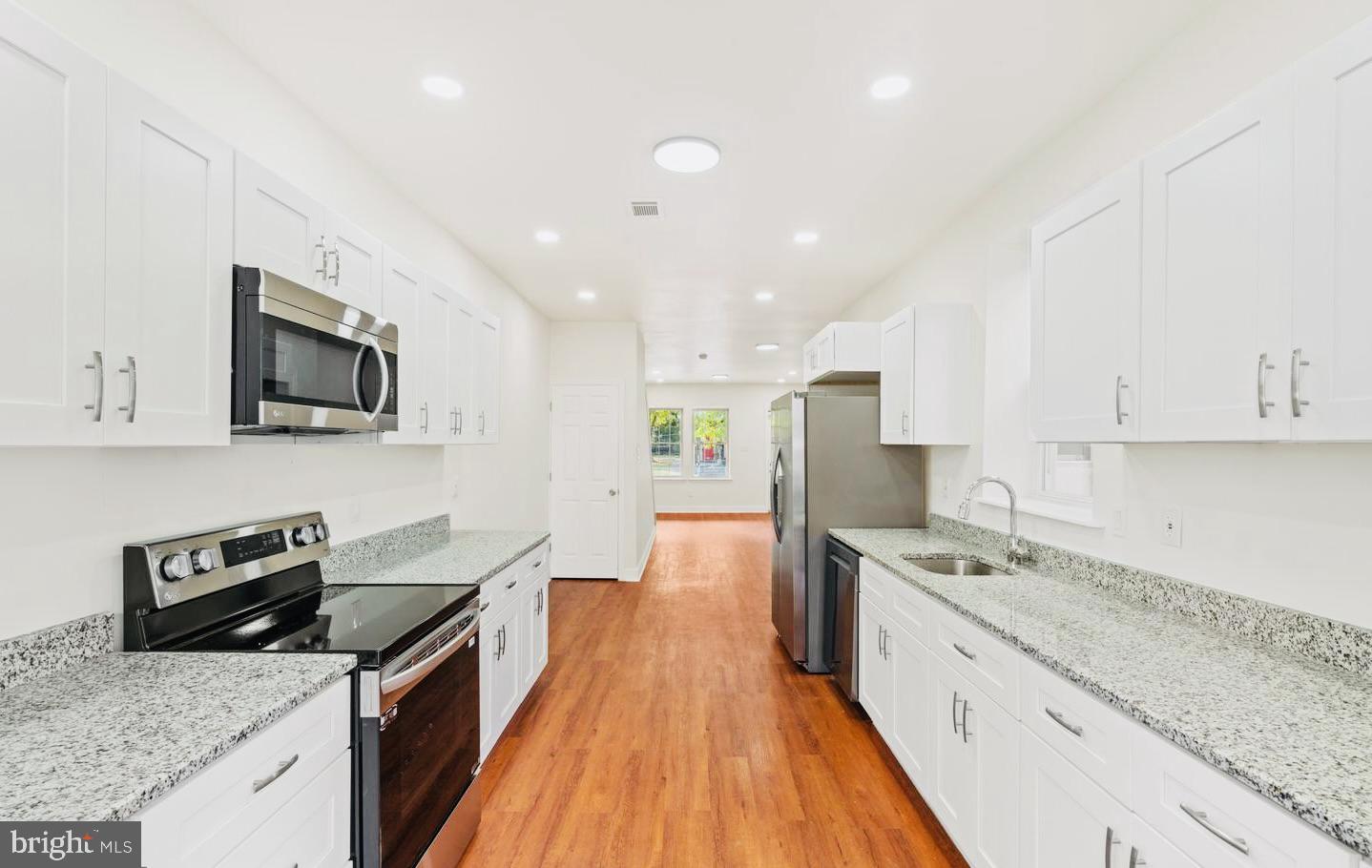4847 Fairmount Avenue Philadelphia, PA 19139 - Photo 6 of 35 a large kitchen with a stove top oven a sink a counter space and cabinets