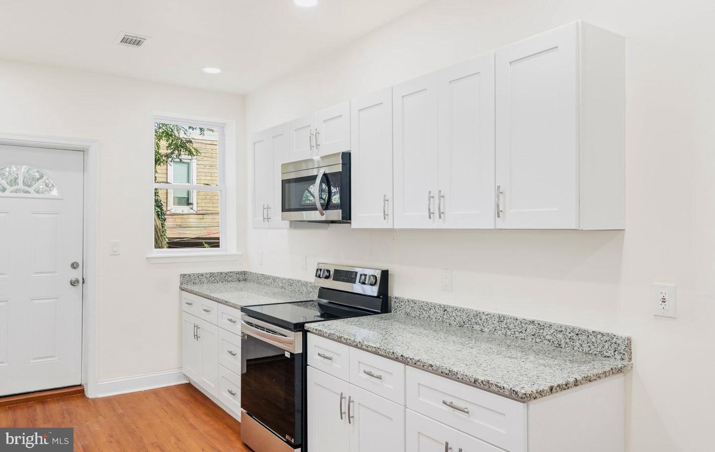 4847 Fairmount Avenue Philadelphia, PA 19139 - Photo 9 of 35 a kitchen with granite countertop white cabinets and white appliances