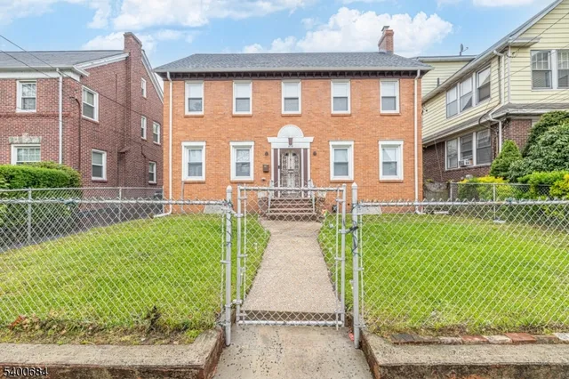 a front view of a house with a garden and plants